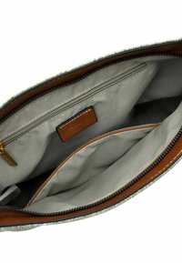 Interno della borsa in tessuto grigio con dettagli in pelle marrone, dotato di un compartimento principale, tasca con zip e due tasche aperte per l'organizzazione.