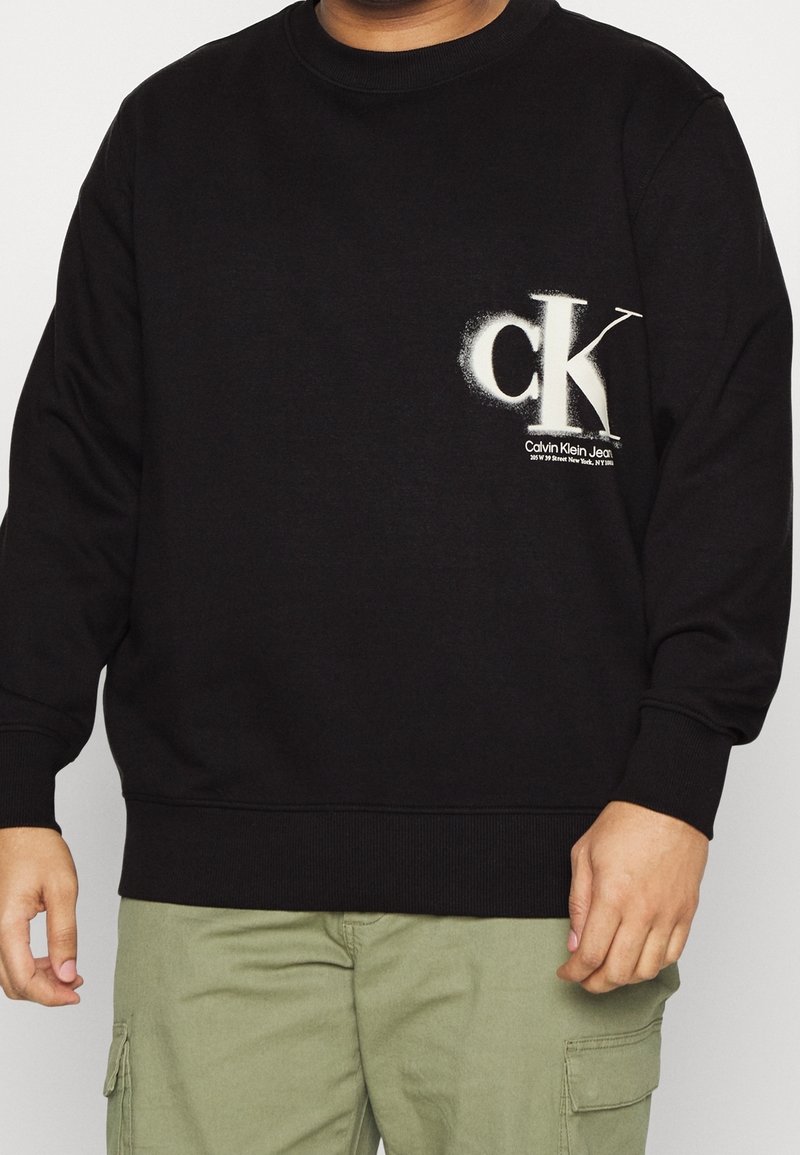 Svart sweatshirt med rund hals, ribbstickade ärmslut och nederkant. Utrustad med vitt "ck"-logo med texturerade detaljer på vänstra bröstet.