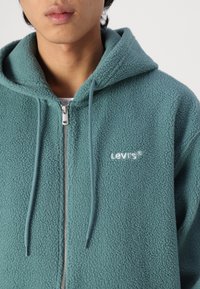Levi's® GRAPHI ZIP UP - Jachetă din fleece - turquoise