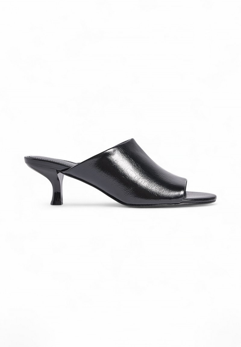 Mules negros de punta abierta hechos de material sintético brillante. Cuenta con un diseño elegante con un tacón cuadrado de altura media y una textura de superficie suave.