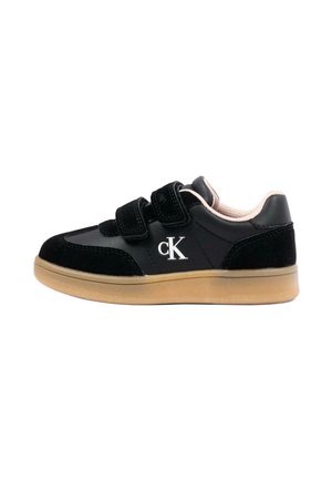 Czarny niski sneaker z beżową podeszwą, dwoma paskami na rzep i białym logo "cK" na boku, pokazany od zewnętrznej strony.