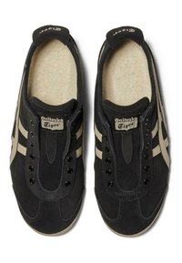 Černé semišové tenisky s béžovými pruhy, kulatou špičkou, šněrováním v přední části, měkkou podšívkou a značkovým jazykem. Obsahují kovové nýty.