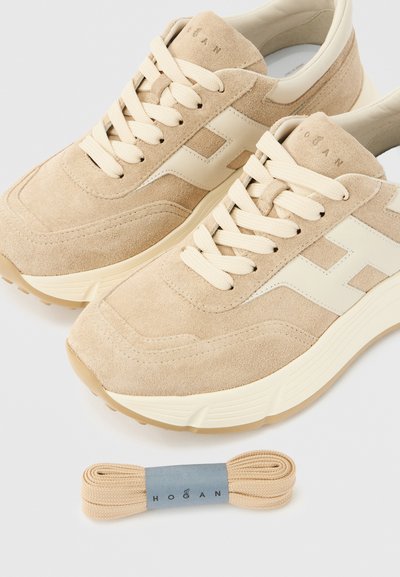 Μπεζ σουέντ αθλητικά παπούτσια με εκρού  λεπτομέρεια από δέρμα και υφασμάτινη γλώσσα με υφή. Περιλαμβάνουν μπεζ κορδόνια που ταιριάζουν.