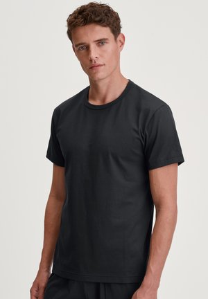 Schwarz kurzärmliges T-Shirt aus weicher Baumwolle, mit Rundhalsausschnitt und einem lässigen Schnitt. Glatte Textur mit minimal sichtbaren Nähten.