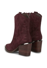 Botines de ante burdeos con costuras en zigzag, puntera redondeada y tacones de madera apilados. Incluyen un cierre de cremallera en la parte posterior.