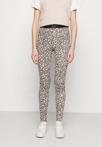 Los leggings estampados presentan un diseño floral en negro, beige y tonos pasteles. Están hechos de una tela elástica con una forma ajustada y una cinturilla alta.