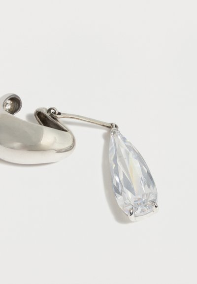 Ασημένιο σκουλαρίκι κρίκος με μεγάλο κρεμαστό διαφανές πολύγωνο δάκρυ κομμάτι σε λευκό φόντο.