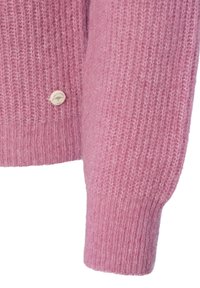 Rosa gestrickte Strickjacke mit einer strukturierten Oberfläche, die mit einem runden, hellen Knopf verziert ist. Das Design umfasst gerippte Bündchen und einen gerippten Saum.