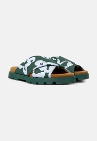 Infradito verdi con fasce incrociate in tessuto caratterizzate da un motivo astratto bianco, una suola interna imbottita color beige e una suola verde texturizzata.