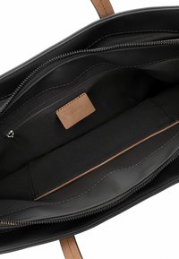 Borsa a spalla in pelle nera con un ampio interno, dotata di tasca con zip, dettagli cuciti e un'etichetta in pelle marrone chiaro a contrasto.