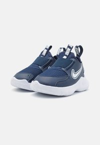 Modré športové topánky vyrobené z textilu a kože, s suchým zipsom, bielou medzivojenskou podrážkou a akcentom loga Nike na boku.