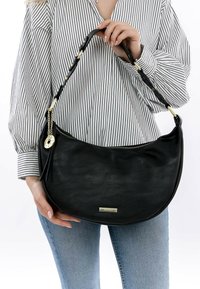 Borsa a spalla in pelle nera con una forma curva, dotata di una tracolla intrecciata, dettagli in metallo dorato e una superficie testurizzata.