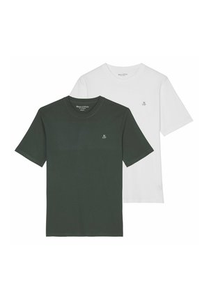 Mann trägt ein schlichtes weißes T-Shirt mit kurzen Ärmeln und kleinem "MOP" Logo auf der linken Brust sowie beigefarbene Hosen.