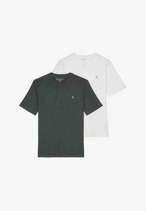 Uomo con una semplice t-shirt bianca a maniche corte con un piccolo logo "MOP" sul petto a sinistra e pantaloni beige.