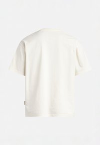 T-shirt a maniche corte e girocollo in cotone bianco sporco. Presenta un design semplice con un taglio dritto e una piccola etichetta sul lato.