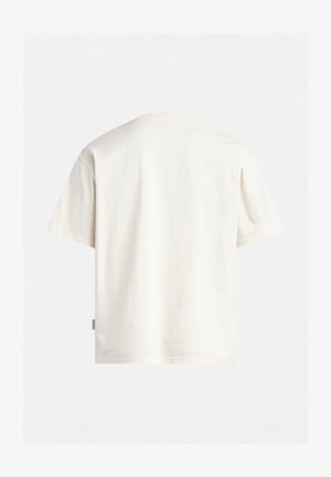 Cremfarbener Baumwoll-T-Shirt mit lockerem Schnitt, kurzen Ärmeln und Rundhalsausschnitt. Verfügt über ein kleines seitliches Etikett nahe dem Saum.