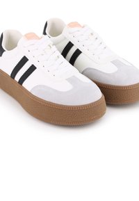 Zapatillas blancas y grises con rayas negras, que presentan una suela de goma texturizada y un diseño de cordones. Materiales suaves de ante y sintéticos.