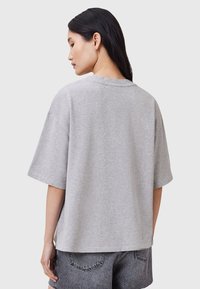 Grå oversized t-shirt med rund hals, korte ærmer og blød tekstur. Har et simpelt, udeladt design velegnet til afslappet brug.