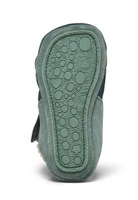 Suola in suede verde con motivo in gomma testurizzata caratterizzata da forme circolari e dettagli giocosi. Gli accenti suggeriscono un design leggero e flessibile.