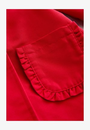 Material roșu cu textură netedă, având o buzunar decorat cu margini plisate. Cusătura este îngrijită, evidențiind măiestria lucrării.