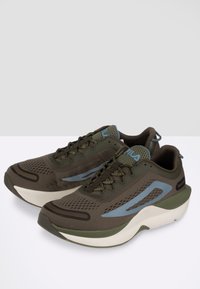 Scarpe da atletica di colore verde scuro e blu, con una tomaia in rete testurizzata, design con lacci e una suola bianca imbottita con una forma curvata.