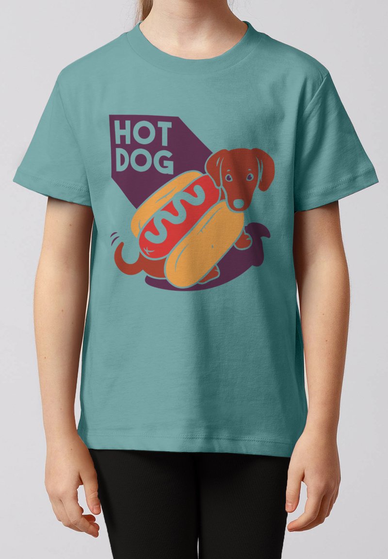 Enfant portant un t-shirt bleu sarcelle avec une illustration d'un chien teckel dans un pain hot-dog et le texte "HOT DOG" sur le devant.