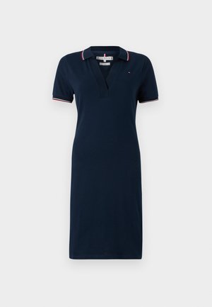 Jūras spēku polo kleita ar īsām piedurknēm, V-veida kakla izgriezumu un strukturētu kokvilnas maisījumu. Ar sarkaniem un baltiem svītrainiem akcentiem uz apkakles un piedurknēm.