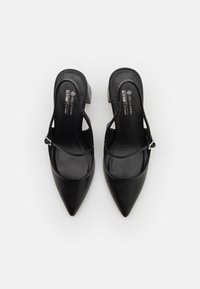 Musta vegan-nahka slingback-korkokengät, joissa on terävä kärki ja matala lohkokorko. Ominaisuuksiin kuuluu ohut nilkkastrappi, jossa on hopeinen solki.