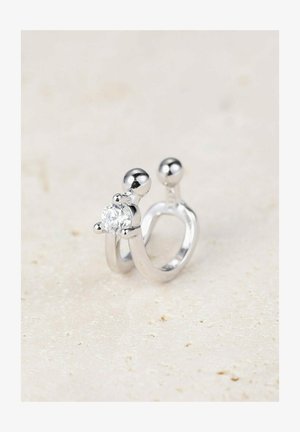 Anello in argento con una pietra centrale trasparente, due sfere arrotondate in cima, texture liscia e un design aperto contemporaneo.