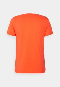 Oranžové tričko s krátkým rukávem vyrobené z bavlny. Jednoduchý design s kulatým výstřihem a bez vzorů nebo ozdob. Hladká textura.