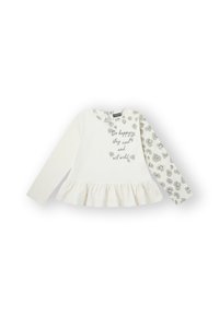 Blusa de manga larga color crema con dobladillo volante, que presenta un estampado de leopardo gris en una manga y letras plateadas que dicen "Sé feliz, mantente fresco y actúa salvaje."