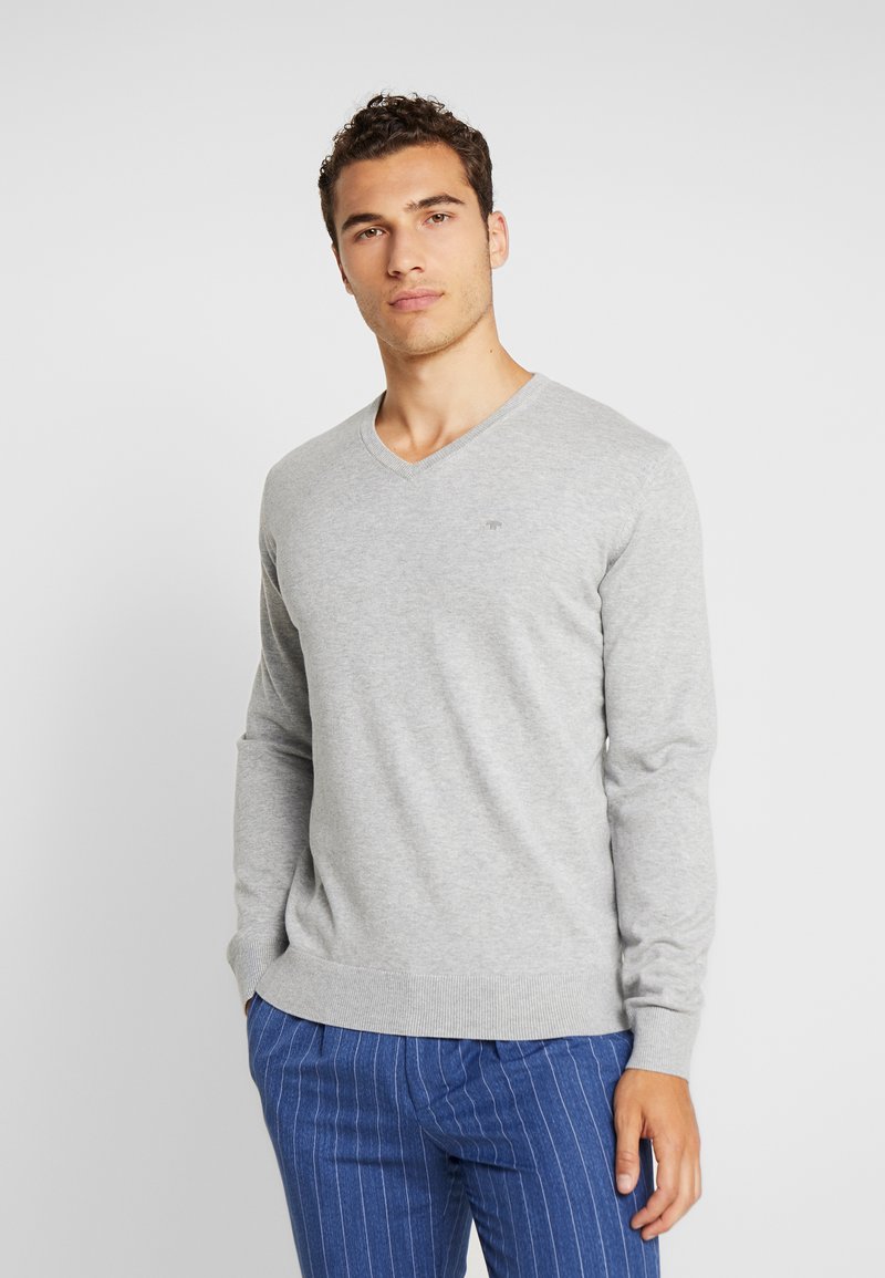 Szary sweter typu V-neck z długimi rękawami, ściągaczami przy rękawach i dołem. Tkanina wydaje się miękka z delikatną teksturą. Małe logo na klatce piersiowej.
