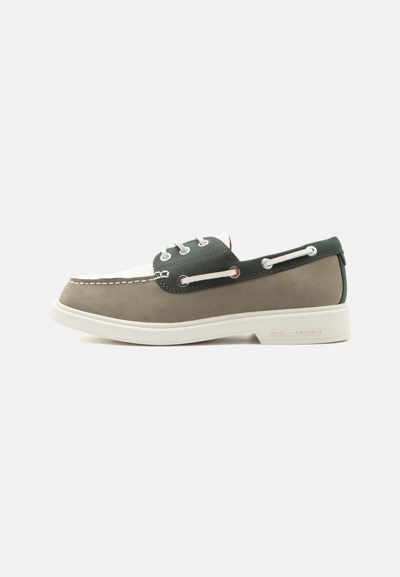 Mocassin profil bas avec panneaux gris, blancs et vert foncé, lacets blancs, semelle blanche et détails de lacets latéraux sur fond uni.