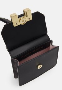 Sac en cuir noir avec un fermoir doré, comportant un intérieur rose. Il a un design structuré et un compartiment unique pour le rangement.