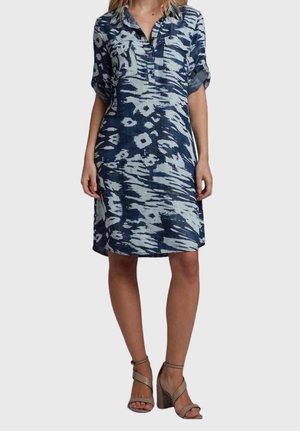 Robe à manches courtes avec boutonnière en bleu marine, ornée d'un motif abstrait blanc. Dotée d'un col et de deux poches poitrine. Confectionnée en tissu léger.