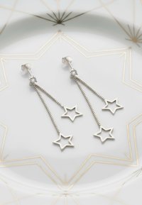Silverhänge i droppform med en kedjedesign som har två stjärnformade hängen och klara ädelstensaccenter vid stiftet. Texturerad silverfinish.