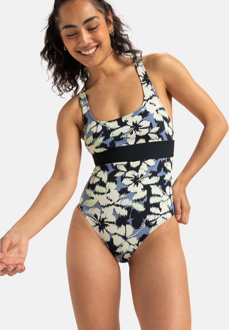 Maillot de bain une-pièce avec un motif floral dans des nuances de bleu, vert et noir, avec une large bande noire à la taille et un décolleté en forme de scoop.