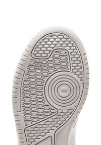 Suola di una scarpa da ginnastica bianca, con gomma testurizzata caratterizzata da motivi circolari e esagonali, bordi arrotondati e finitura liscia.