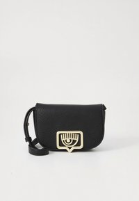 Borsa a tracolla in pelle nera con patta a pieghe, dotata di dettaglio hardware dorato a forma di occhio e tracolla sottile regolabile.