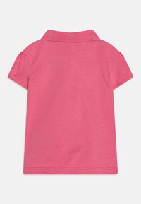 Růžová polo košile s krátkým rukávem s jednoduchým designem, žebrovaným límcem a hladkým bavlněným povrchem. Zadní pohled bez viditelných vzorů nebo detailů.