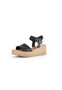 Sandal de cuña de cuero negro con punta abierta y tira, que incluye un cierre de hebilla y una base de textura de madera clara.