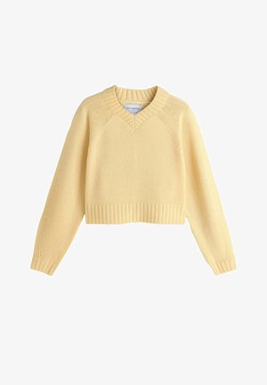 Gul cropped sweater lavet af 100% lammeuld, med V-udskæring, ribbede manchetter og kant, samt strukturstrik detalje på ærmerne.