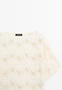 Witte kanten top met korte mouwen, met geschulpte bloemmotieven, ronde halslijn en Massimo Dutti-label aan de kraag.