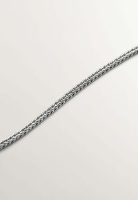 Cable de carga trenzado en plata, con un acabado metálico suave, que presenta giros intrincados y un diseño flexible para mayor durabilidad.
