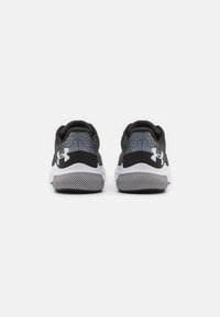 Schwarze und graue Sportschuhe mit einem Obermaterial aus Mesh, gepolstertem Kragen und Gummisohle mit einem strukturierten Profil. Weiße Akzente an der Sohle.