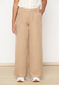 Beige wide-leg trousers with vertical white stripes. Features a button and zipper closure, side pockets, and a textured fabric finish.