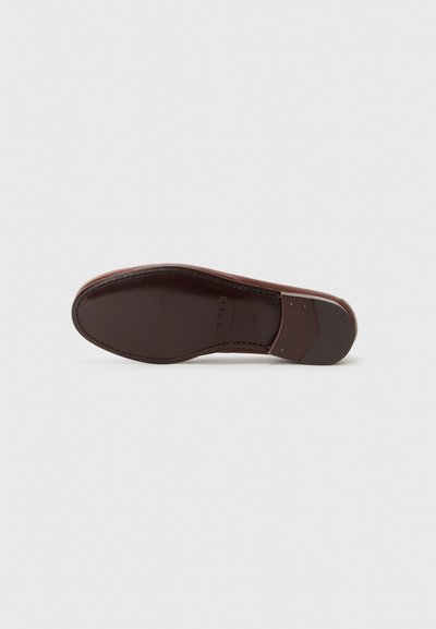 Suela de zapato de cuero en marrón oscuro, con una textura suave y un tacón redondeado. Destaca por su costura en contraste y un ligero afinamiento del tacón.