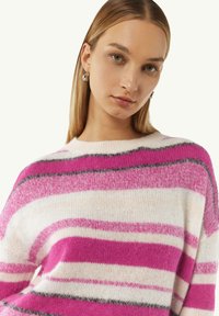 Gestreifter Pullover in rosa, weiß und grauen Farbtönen. Weiche Textur, runder Ausschnitt und lockere Passform. Merkmale breite horizontale Streifen über den Körper.