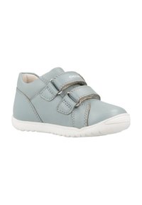 Chaussure en cuir bleu clair avec deux sangles Velcro, semelle en caoutchouc blanche, bout arrondi et détails de couture contrastés le long des côtés.