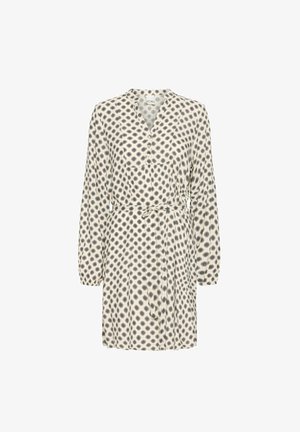 Kemična obleka v kremni barvi s črnim spiralnim pikčastim vzorcem, dolgimi rokavi, zategnjenim pasom in mehkim materialom. Ima ovratnik v obliki črke V.